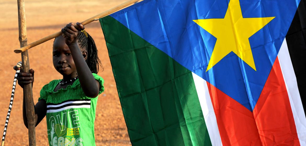 A girl raising the flag of South Sudan. Image: Wikimedia (CC)