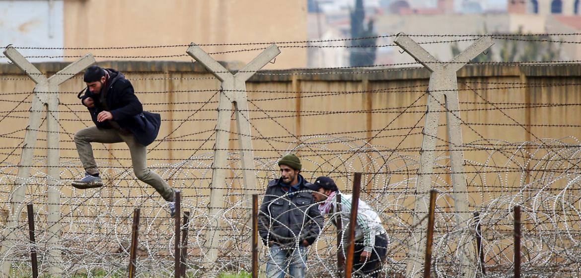 Ein Syrer springt durch den Stacheldraht an der Grenze zur Türkei. Foto: Freedom House (Reuters/Laszlo Balogh) / Flickr (https://flic.kr/p/dEkRMH), Lizenz: cc-by 2.0 (https://creativecommons.org/licenses/by/2.0/)