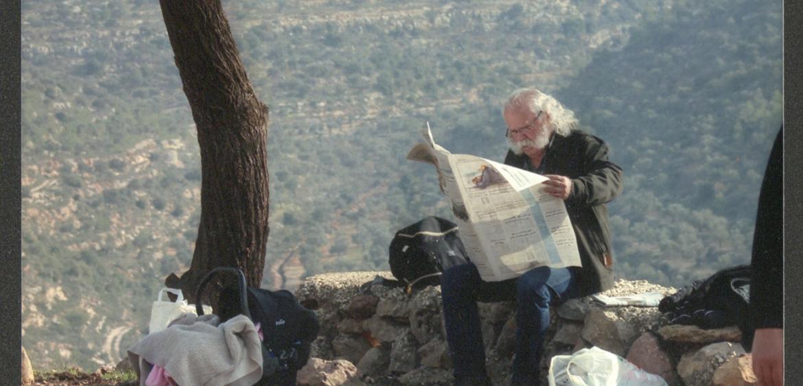 Adel Tartir unter einem Baum am Zeitung lesen. Foto: www.adeltartir.com