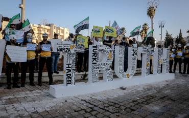 Demonstrierende in Idlib stehen hinter einer Skulptur des Wortes „Truth". Foto: Ahmed Akacha