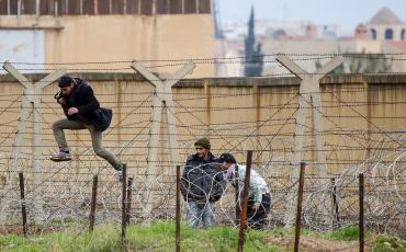 Ein Syrer springt durch den Stacheldraht an der Grenze zur Türkei. Foto: Freedom House (Reuters/Laszlo Balogh) / Flickr (https://flic.kr/p/dEkRMH), Lizenz: cc-by 2.0 (https://creativecommons.org/licenses/by/2.0/)